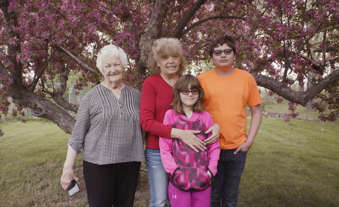 A women poses with her daughter and grandchildren